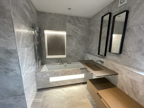 Bathroom with freestanding bath and backlit mirror