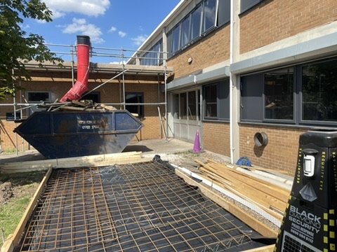 Reinforced concrete groundworks during a pour at the school