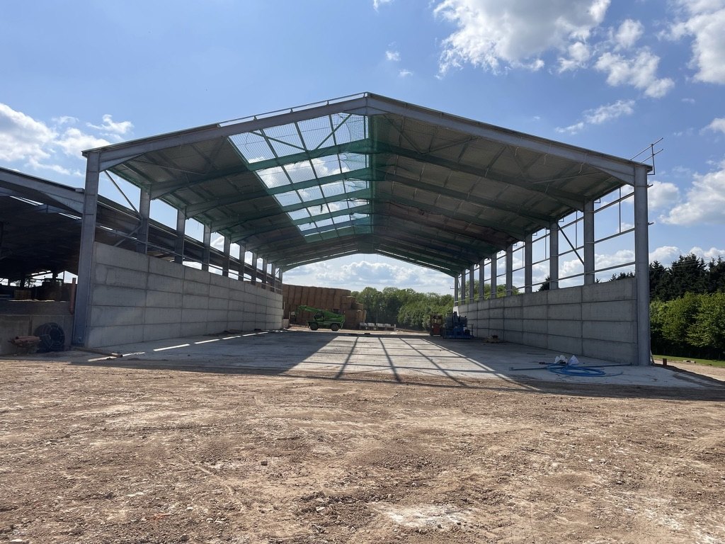 Completed steel-frame cattle building with concrete panel walls at Howard Farms